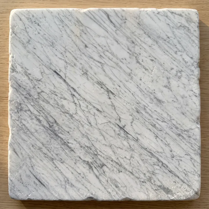 Carrara marble slab with an antiqued, matte finish and worn edges