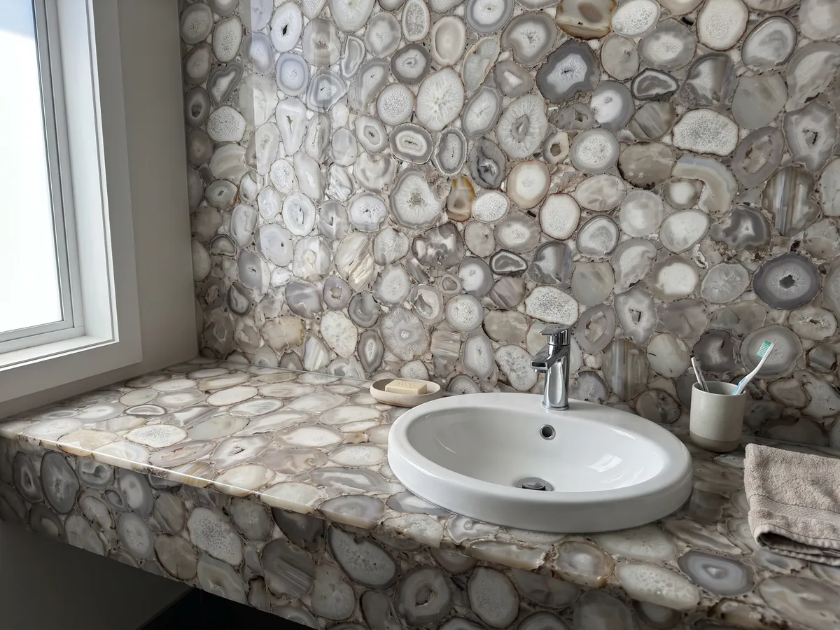 Vanity top and bathroom wall in gray agate with a white sink and chrome faucet: gray-beige and white agate slices in neutral tones