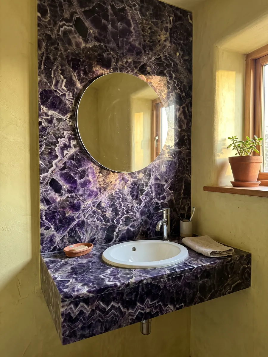 Powder room with an amethyst wall and floating vanity under a round mirror: dark violet crystals with white and lilac zigzag bands