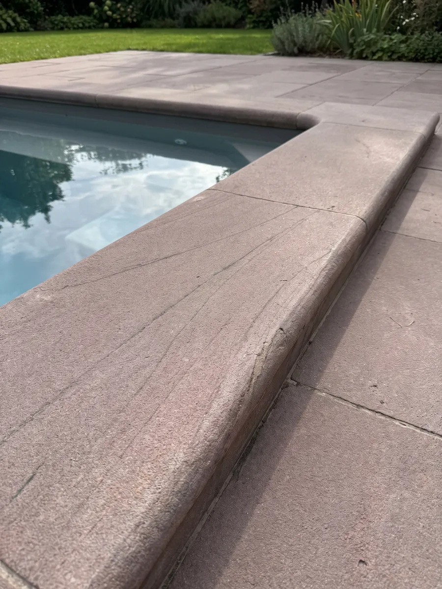 Pool coping and surround in Santafiora Brown sandstone in a house garden: an almost uniform mauve, fine-grained surface with no marked veins