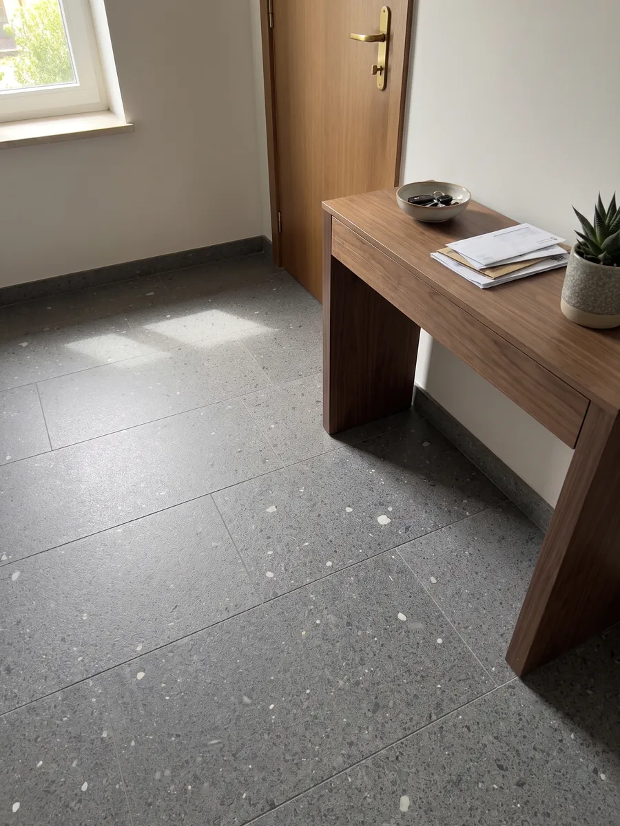 Entryway floor in large Lavagrigia basalt slabs with natural light: granular salt and pepper purplish gray with scattered white inclusions