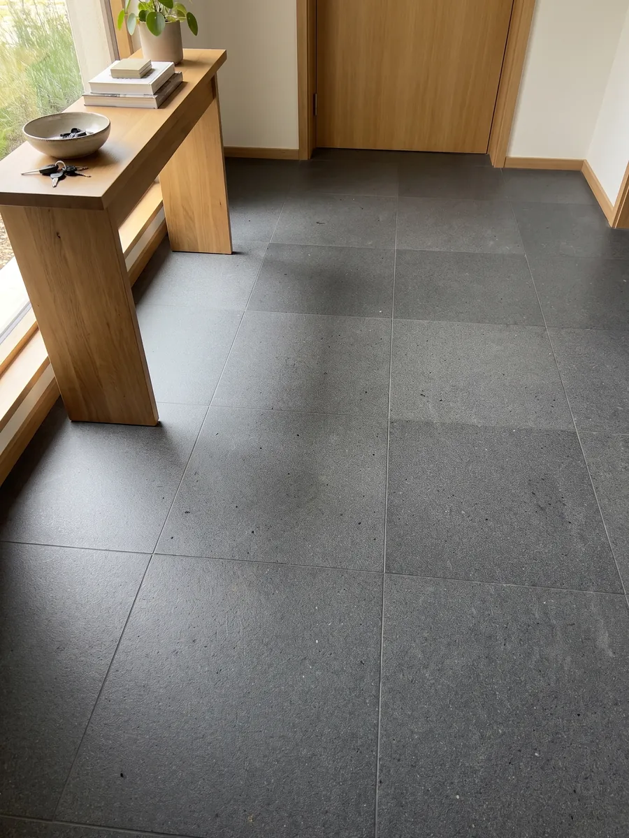 Entryway floor in large Pietra Lavica basalt slabs with natural light: almost black gray, uniform and very fine-grained
