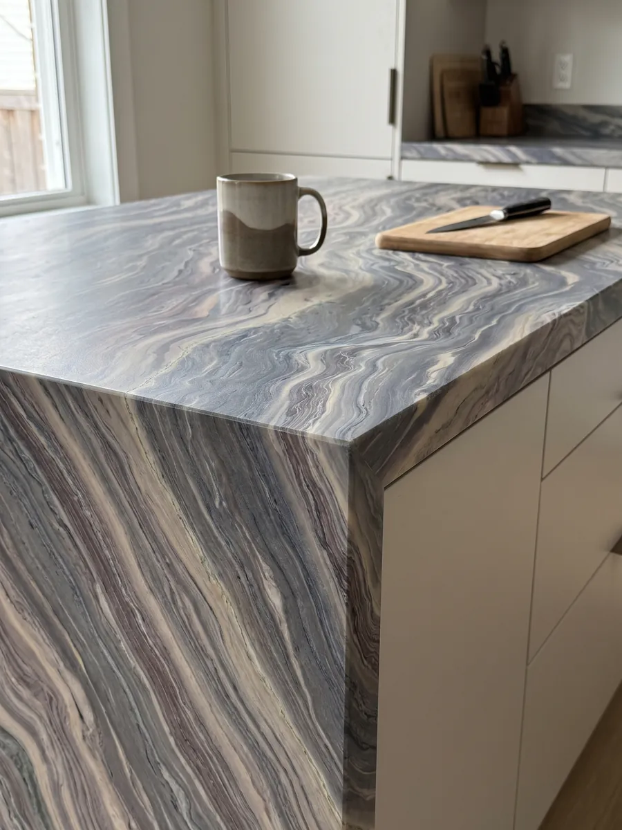 Straight edge of an Explosion Blue quartzite kitchen countertop with the veining running over the edge: tight blue grey and cream waves running across the whole slab on the diagonal