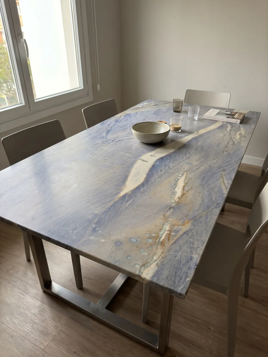 Dining table with an Azul Macaubas quartzite top on a steel base: lavender blue background with a large cream band on the diagonal and ochre touches