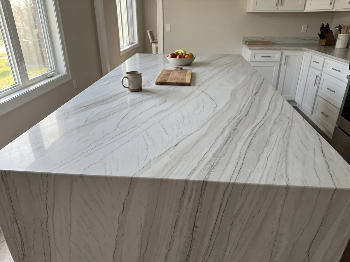 Kitchen island with a White Macaubas quartzite countertop and straight edge in a kitchen with natural light: bluish white with fine parallel dark lines