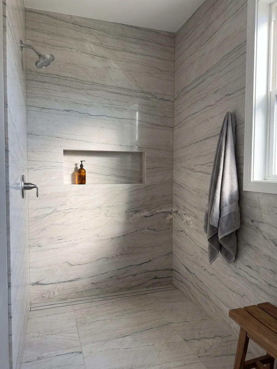 Shower clad in full slabs of white Macaubas Fantasy quartzite with a recessed niche: creamy white with fine horizontal gray-green lines
