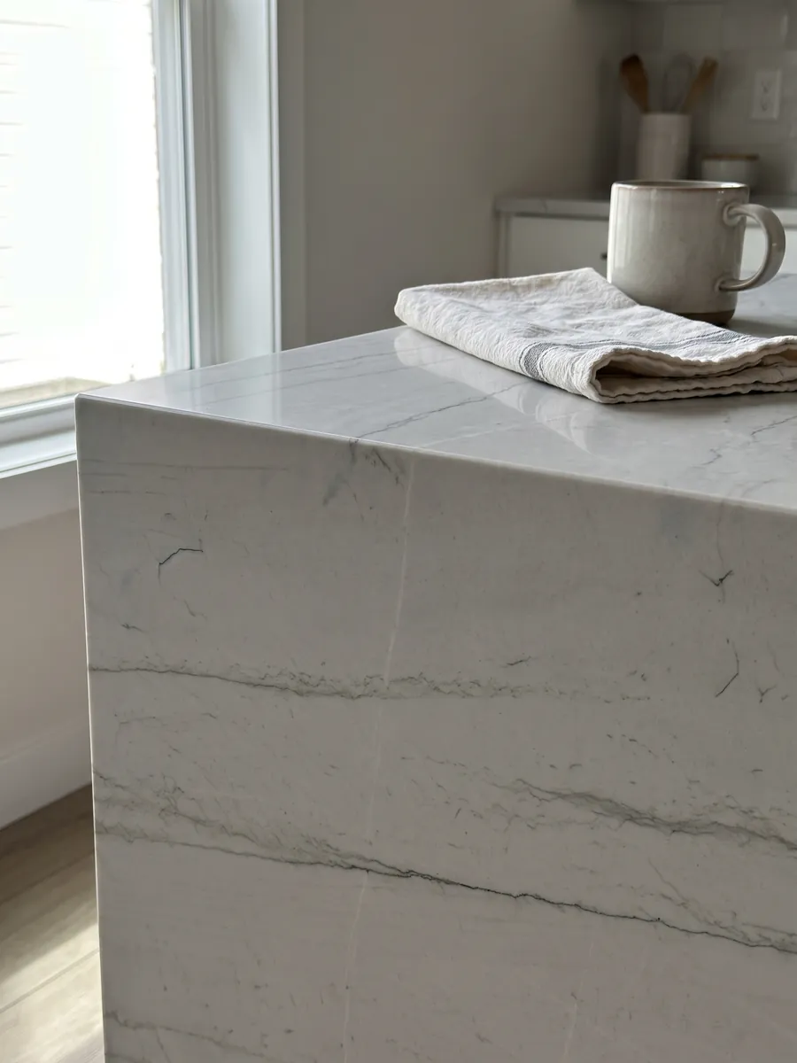 Straight edge of a kitchen countertop in Mont Blanc white quartzite with the vein running over the edge: nearly clean white with two or three very fine gray lines