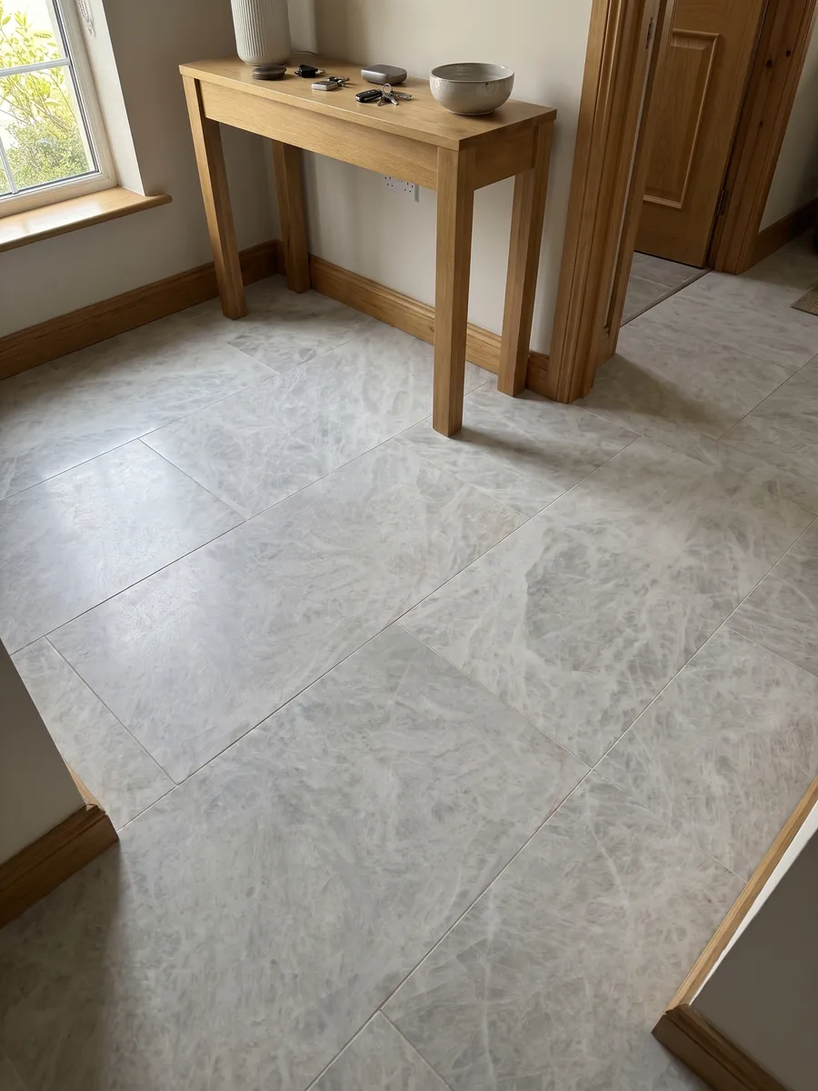 Entryway floor in large grey Cristallo quartzite slabs with natural light: near-uniform greyish white with a soft crystalline look