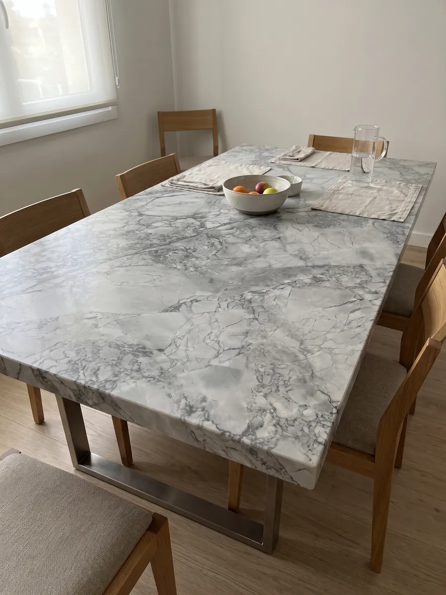 Dining table with a gray Super White quartzite top on a steel base: light gray with a network of slightly darker gray veins
