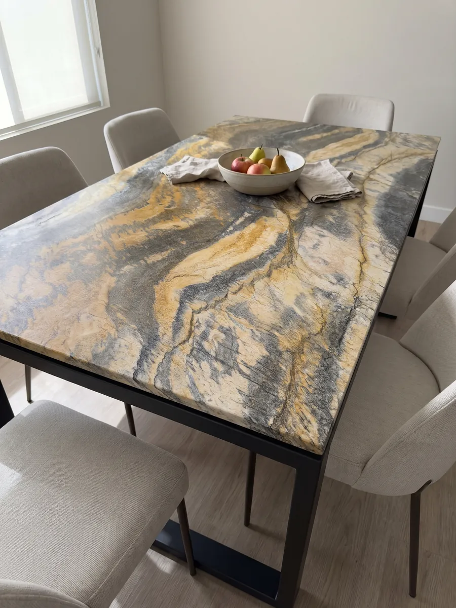 Dining table with a Jacaranda quartzite top on a steel base: wavy bands of mustard yellow and dark gray with plenty of movement