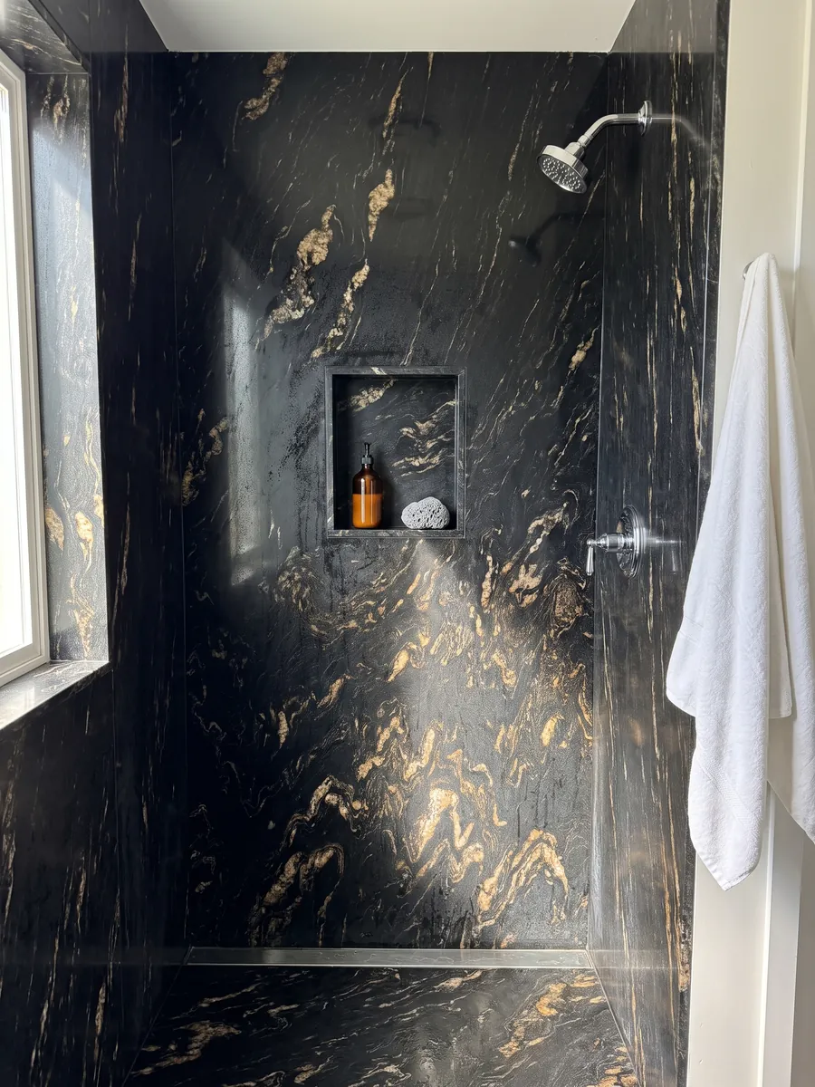 Shower clad in full slabs of black Titanium quartzite with a recessed niche: black with golden and beige flame-shaped inclusions