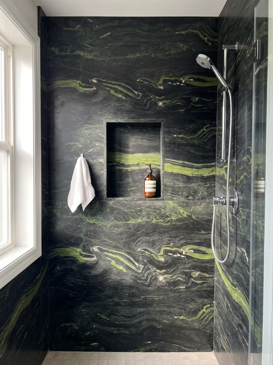 Shower clad in full Vancouver black quartzite slabs with a recessed niche: greenish black with horizontal lime green waves