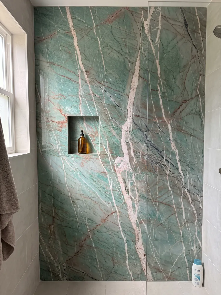 Shower clad in full green Amazzonite Cristallo quartzite slabs with a recessed niche: blue-green crossed by pinkish-white veins and fine reddish lines