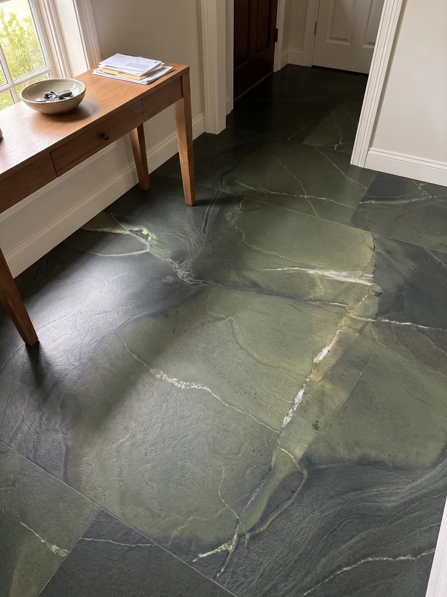 Entryway floor in large green Avocatus quartzite slabs with natural light: deep green in areas, crossed by a few fine white lines