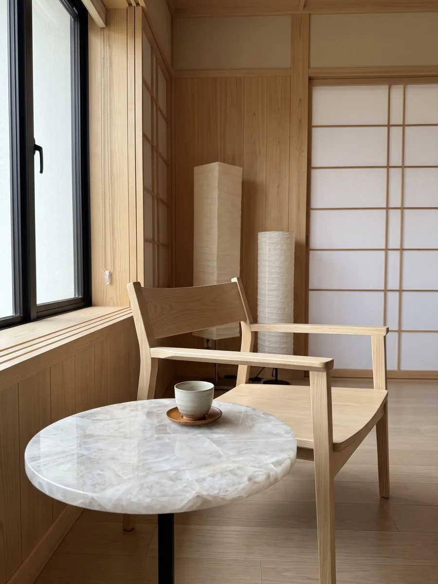 Side table with a White Quartz top next to an armchair: crystalline, soft grayish white with barely marked fragments