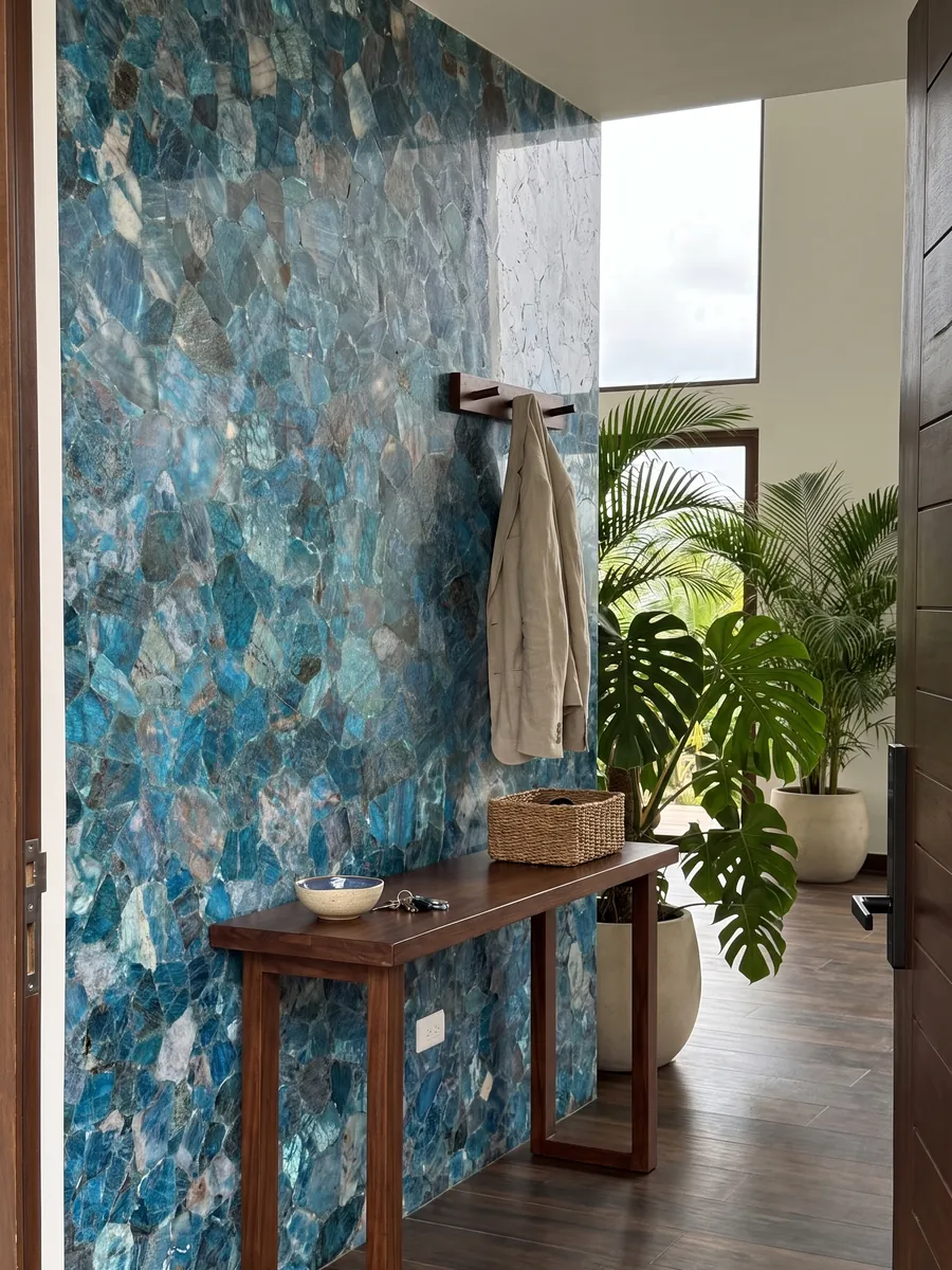 Entryway wall clad in sea quartz with a narrow console: tightly packed turquoise and glassy blue fragments