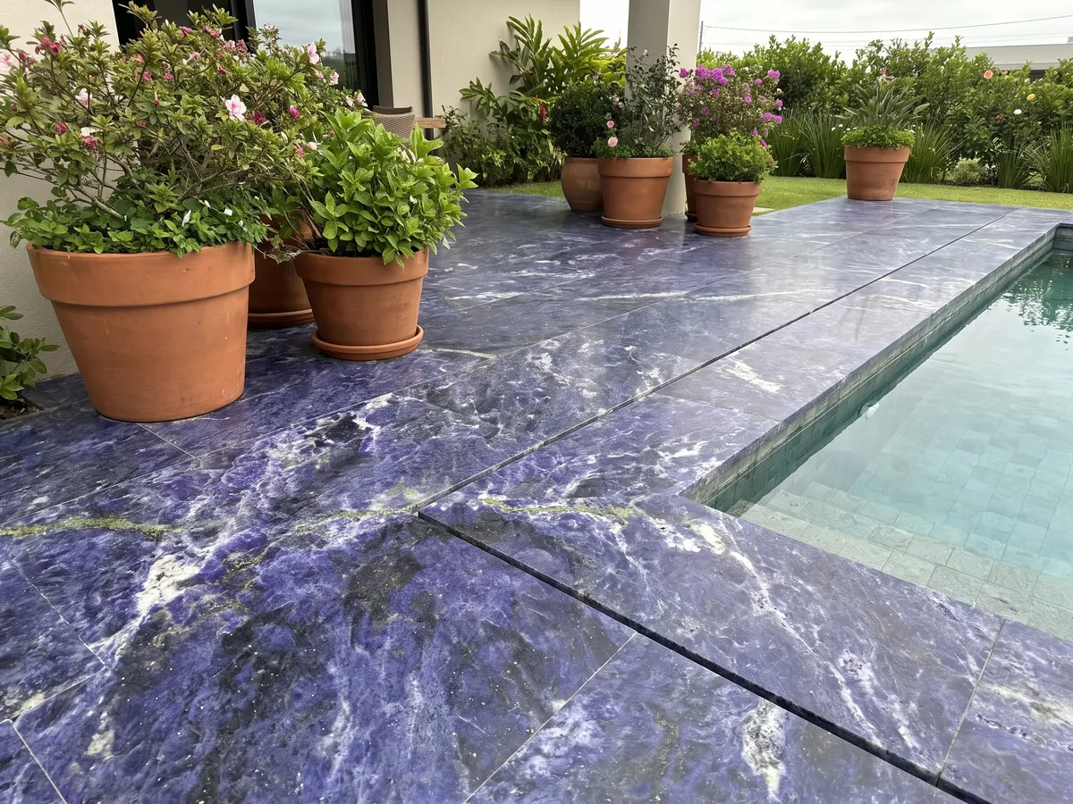 Terrace floor and pool coping in Jeriba Blue granite with planters: intense violet blue with white clouds and a golden green line
