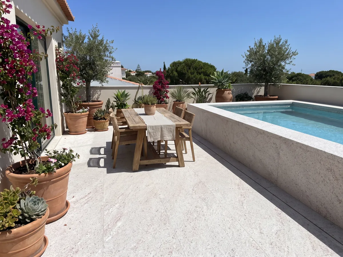 Terrace floor and pool coping in white Branco Siena granite with planters: white with fine pink and gray speckling