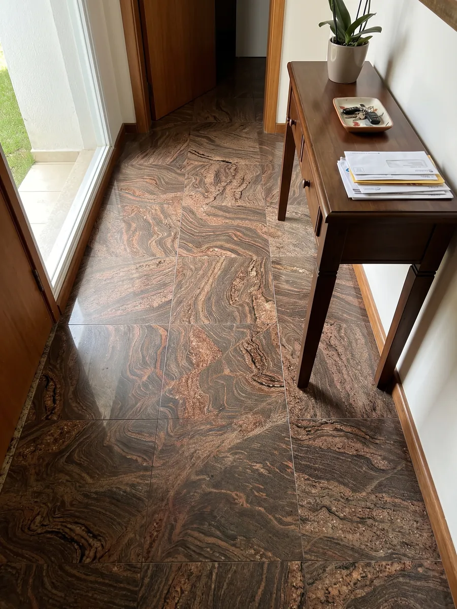 Entryway floor in large Juparana Dourado granite slabs with natural light: ocher brown with very busy reddish waves and swirls