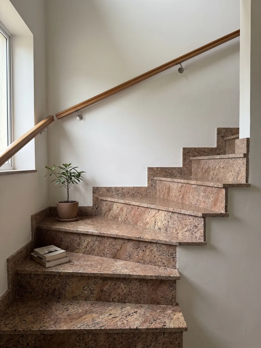 Interior staircase with Juparana Florence granite steps and a handrail: grainy coppery brown with diffuse beige areas