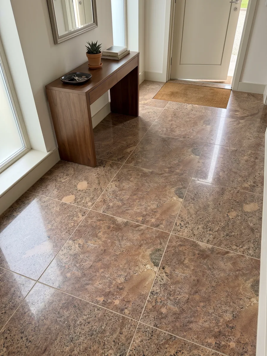 Entryway floor in large Juparana Florence granite slabs with natural light: grainy coppery brown with diffuse beige areas