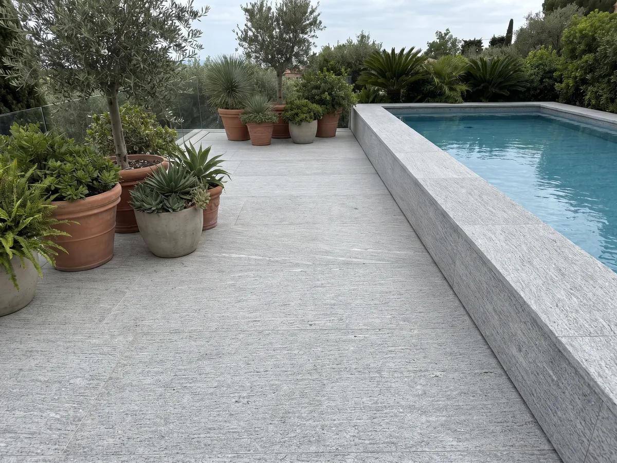 Terrace floor and pool coping in gray Beola Bianca granite with planters: light gray with fine horizontal striping and small glints