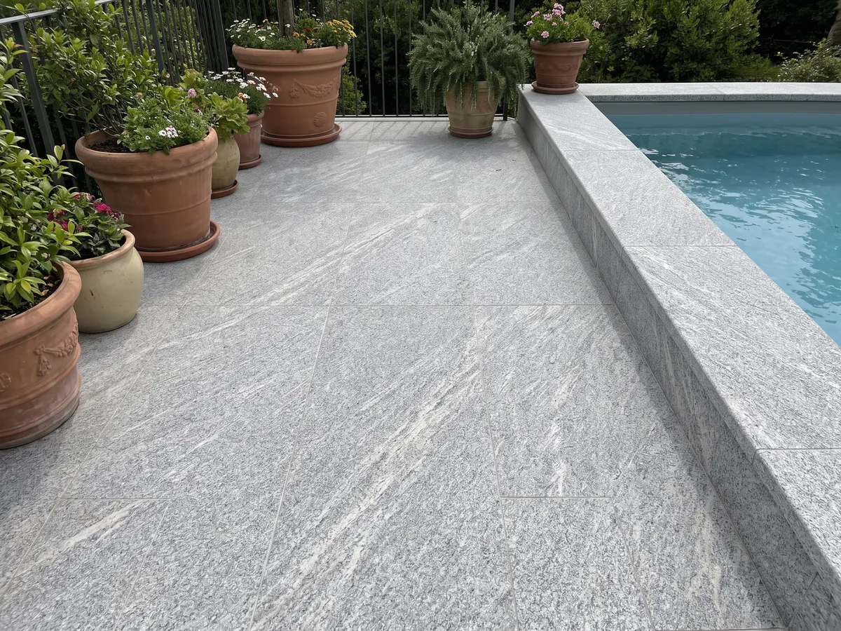 Terrace floor and pool coping in gray Beola Grigia granite with planters: grainy light gray with fine diagonal streaks