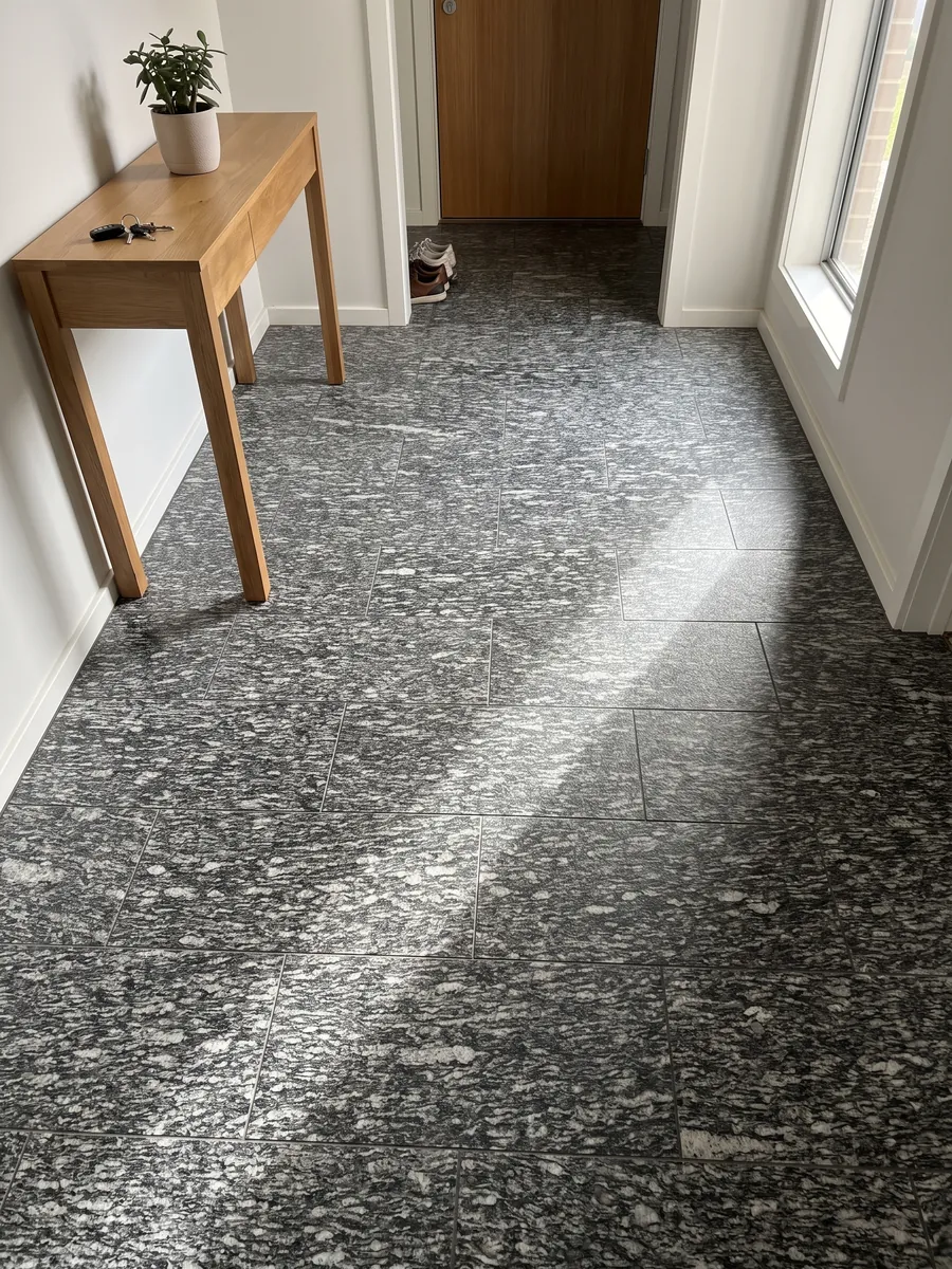 Entryway floor in large Serizzo granite slabs with natural light: dark gray with elongated horizontal white streaks