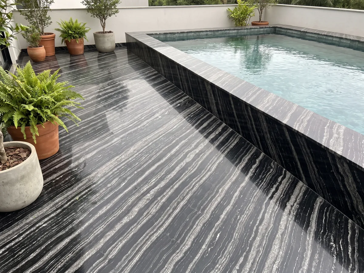 Terrace floor and pool edge in black Agata Black granite with planters: black with parallel diagonal silver gray wavy bands