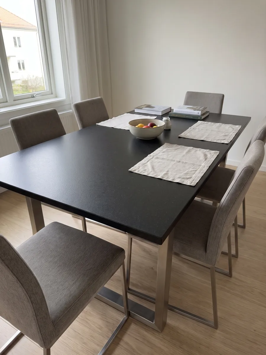 Dining table with a Nero Assoluto black granite top on a steel base: uniform black with no pattern