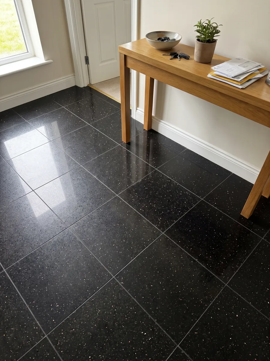 Entryway floor in large black Star Galaxy granite slabs with natural light: black with small shining gold flecks