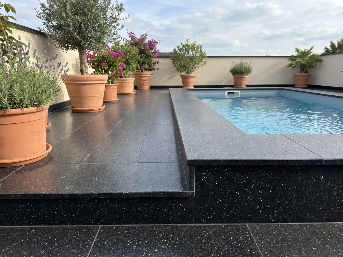 Terrace floor and pool edge in black Star Galaxy granite with planters: black with small shining gold flecks