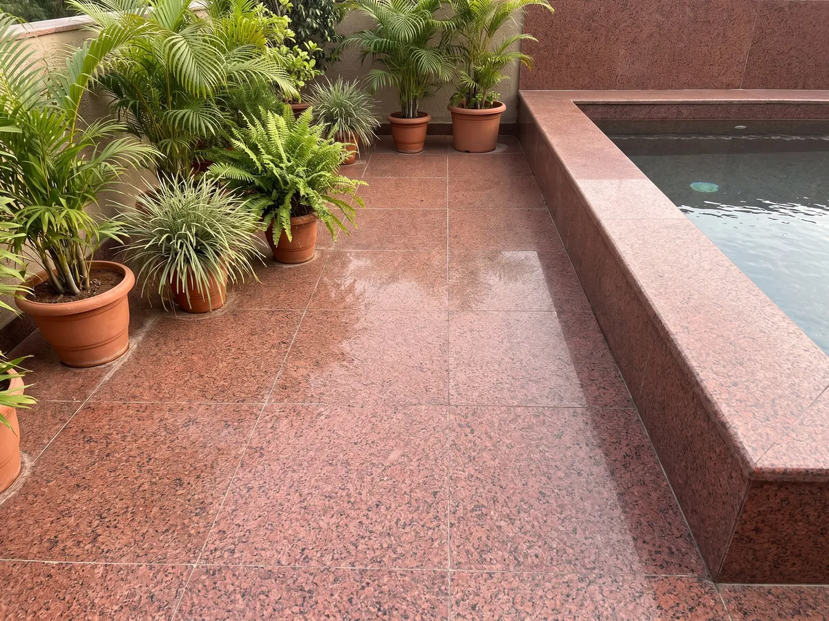 Terrace floor and pool edge in red Balmoral Red granite with planters: deep granular red with black dots spread evenly