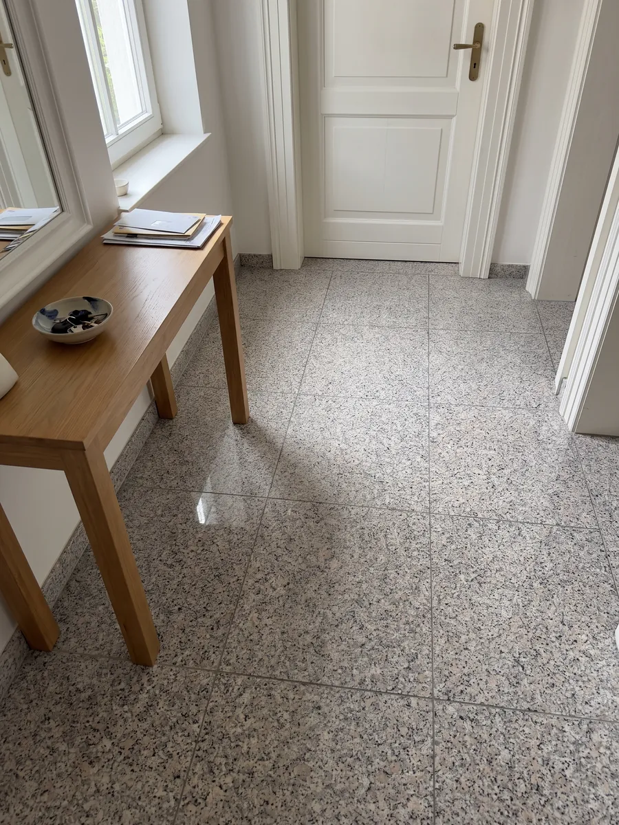 Entryway floor in large Rosa Beta granite slabs with natural light: white grain with pale pink and black dots