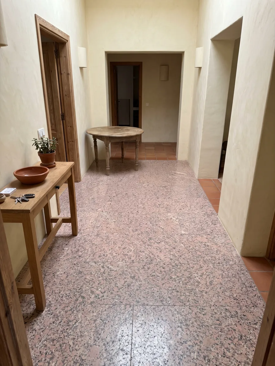 Entryway floor in large Rosa de Salto granite slabs with natural light: mottled pink with dark gray and white speckles