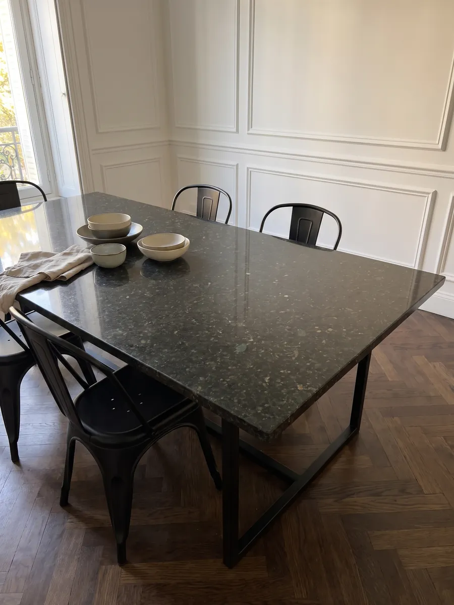 Dining table with a Verde Ubatuba granite top on a steel base: a nearly black green with flashes of light green and gold