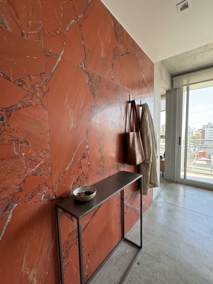 Entryway wall clad in Red Jasper with a narrow console: intense orange-red in large pieces with fine gray joints