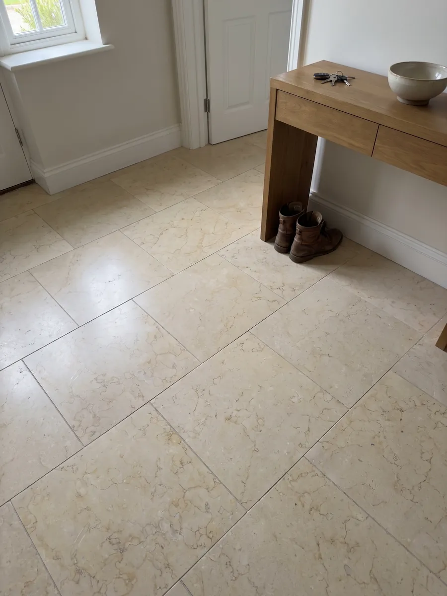 Entryway floor in large slabs of Giallo Silvia Oro marble with natural light: very uniform pale yellow with barely visible fine veining of light lines
