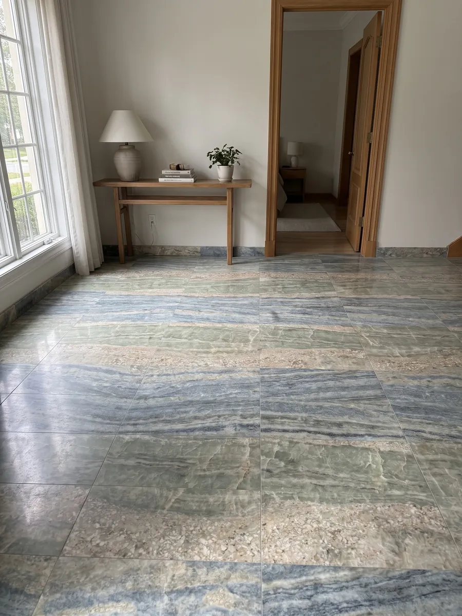 Entryway floor in large slabs of blue Calcite Caraibica marble with natural light: horizontal bands of blue-grey, sage green and beige crystals