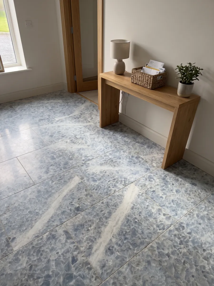 Entryway floor in large slabs of Azul Calcite marble with natural light: thick grayish-blue crystals on white, with a whiter diagonal band