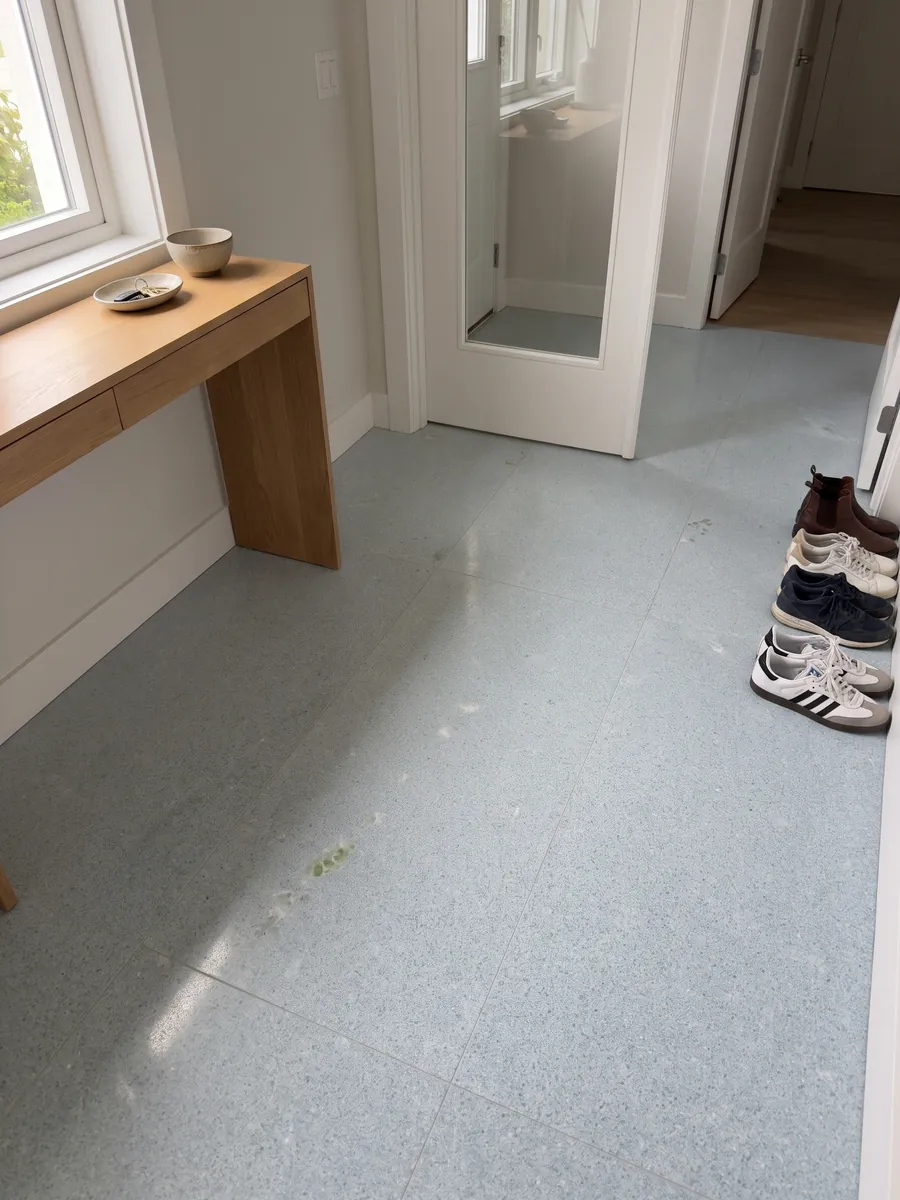 Entryway floor in large slabs of Azul Cielo marble with natural light: nearly uniform pale sky blue, fine-grained, with a green inclusion on the left