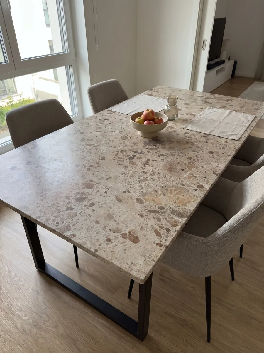 Dining table with a beige Ambrosia marble top on a steel base: beige matrix with rounded brown and rust fragments in several sizes