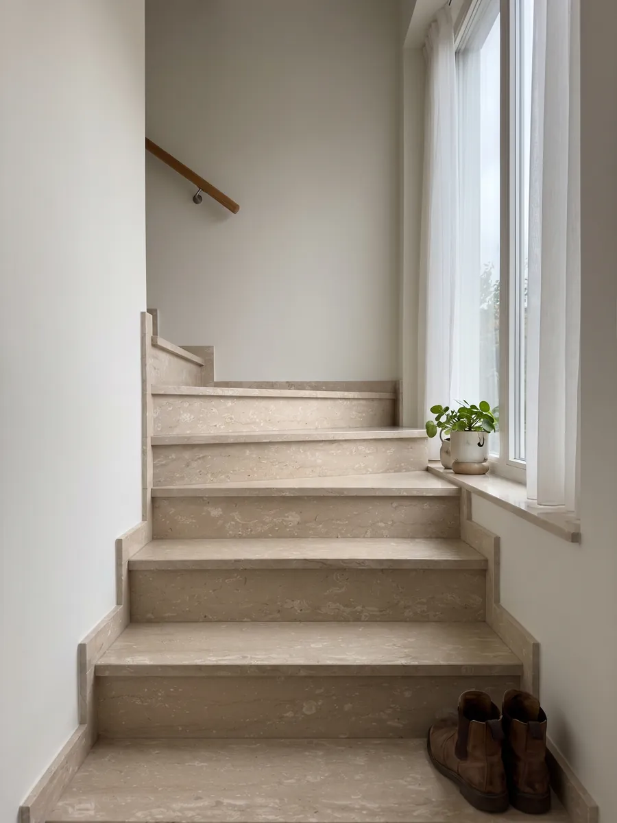Indoor staircase with beige Perlatino marble steps and a handrail: beige with small cream spots lined up horizontally