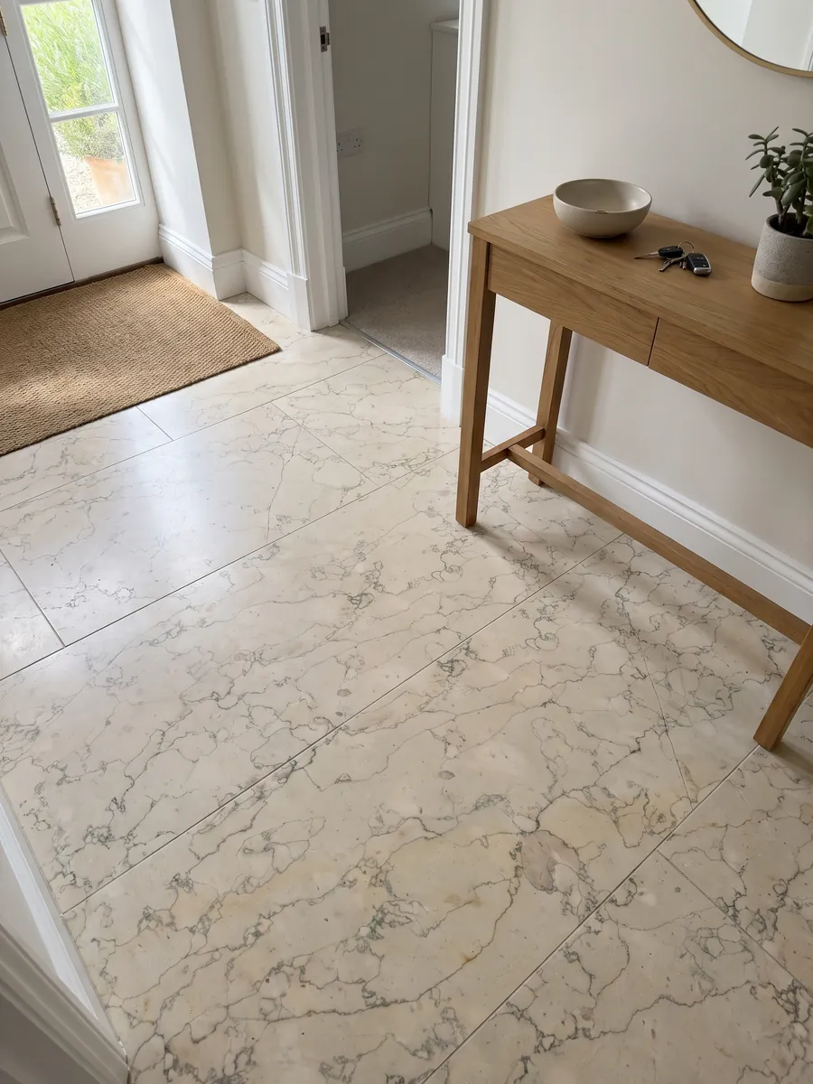 Entryway floor in large Verdello beige marble slabs with natural light: beige background with a fine network of sinuous gray lines, like crackle
