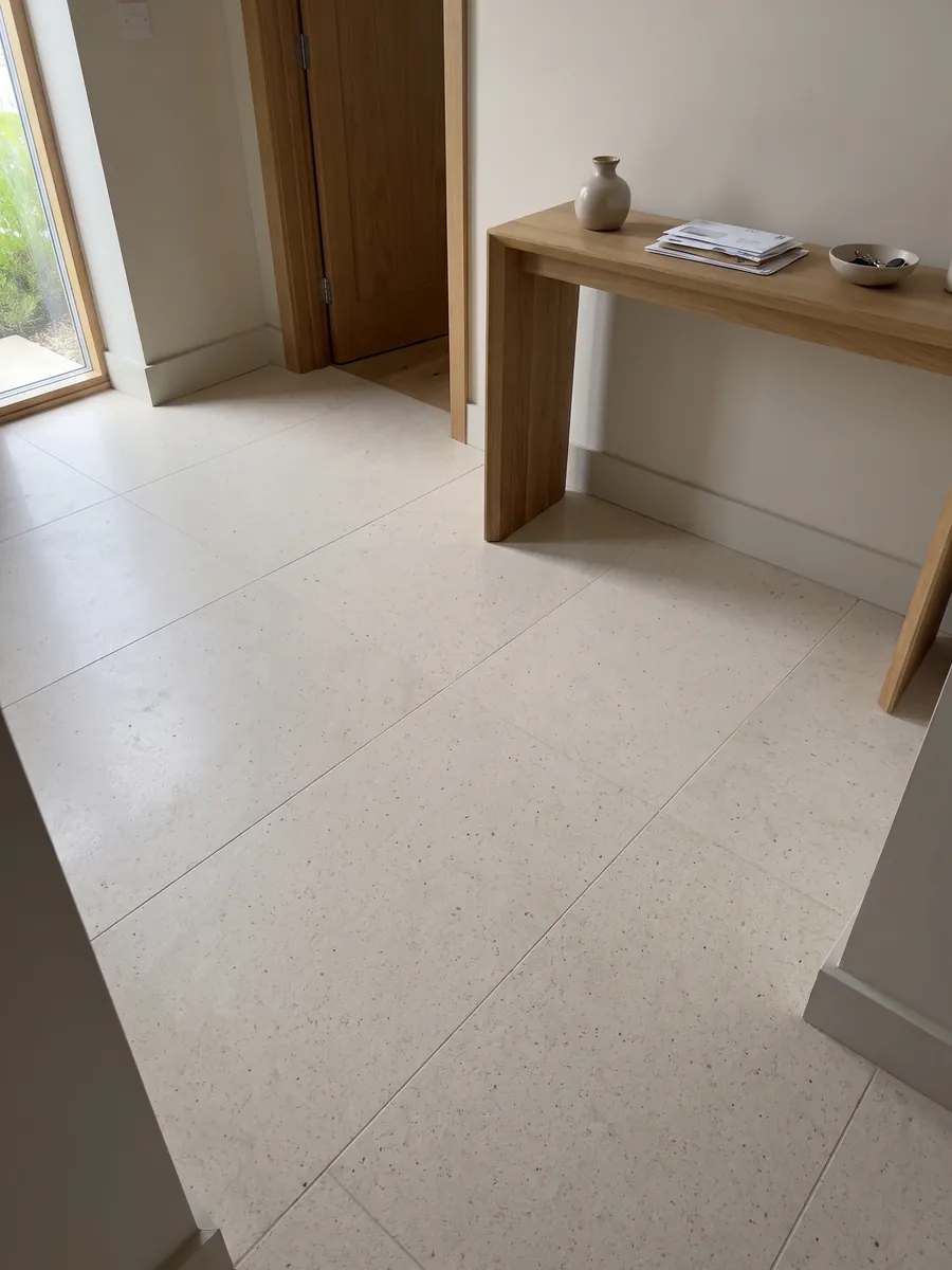 Entryway floor in large beige Veselje marble slabs with natural light: smooth, even cream with barely visible dark specks