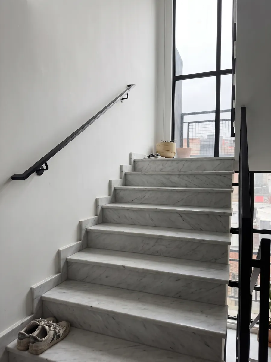 Interior staircase with white Dolomite marble steps and a handrail: grayish white with fine gray veins and the occasional darker line