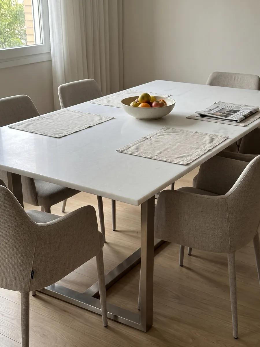Dining table with a Bianco Ghiaccio marble top on a steel base: pure white with almost no visible pattern