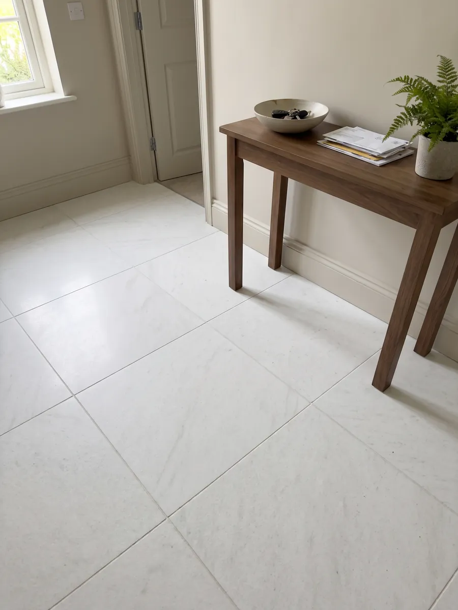 Entryway floor in large slabs of Bianco Ghiaccio marble with natural light: pure white with almost no visible pattern