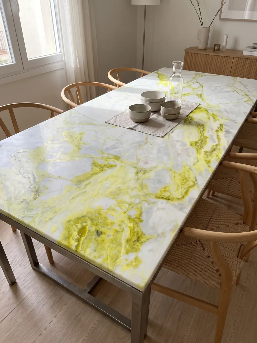 Dining table with a white Luminous marble top on a steel base: bluish white with very intense lemon yellow veins