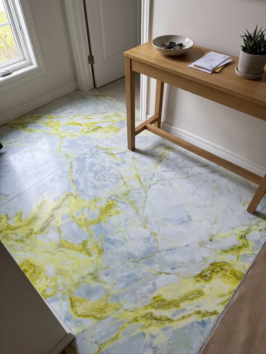 Entryway floor in large slabs of white Luminous marble with natural light: bluish white with very intense lemon yellow veins